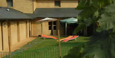 two lawn chairs and an umbrella in a yard at Las Fontaninas in Noceda del Bierzo
