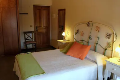 a bedroom with a bed with orange and green pillows at Las Fontaninas in Noceda del Bierzo