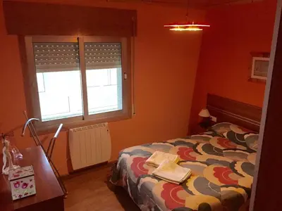 a bedroom with a bed and a desk and a window at M Ramona Reja Díaz in Lourenzá