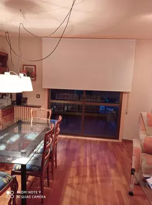 a living room with a table and a large window at Precioso PISO en Villafranca del Bierzo in Villafranca del Bierzo