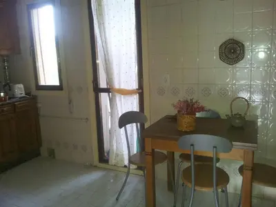 a kitchen with a table and two chairs and a window at Precioso PISO en Villafranca del Bierzo in Villafranca del Bierzo
