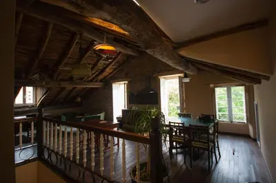 a living room with a wooden ceiling and a table at CASA PELTRE in Sarria