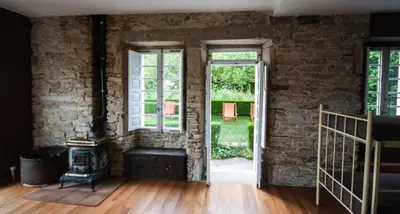 an empty room with an open door and a brick wall at CASA PELTRE in Sarria