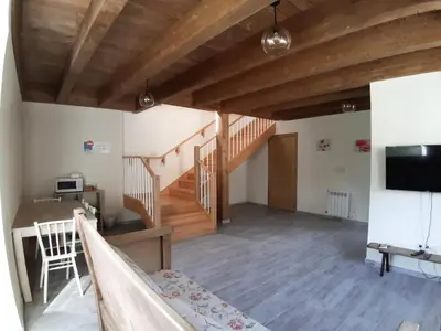 a living room with wooden ceilings and a staircase at Casa Perdigueira in Castromayor