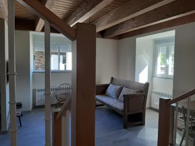 a living room with a couch and two windows at Casa Perdigueira in Castromayor