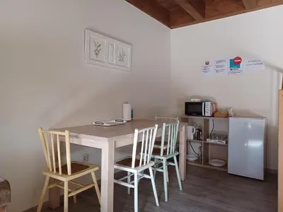 a kitchen with a table and chairs and a refrigerator at Casa Perdigueira in Castromayor
