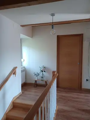 a hallway with a wooden door and a table at Casa Perdigueira in Castromayor