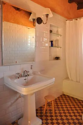 a white bathroom with a sink and a stool at Casa Rural Las Águedas in Murias de Rechivaldo
