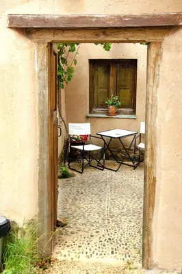 a patio with a table and chairs and a window at Casa Rural Las Águedas in Murias de Rechivaldo