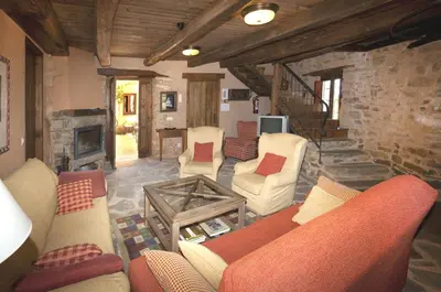 a living room with couches and a fireplace at Casa Rural Las Águedas in Murias de Rechivaldo