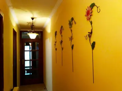 a room with four flowers on a yellow wall at Apartamento La Real in Caldas de Reis