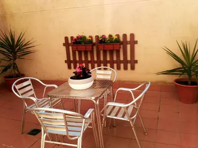 a table and chairs with plants on a patio at Apartamento La Real in Caldas de Reis