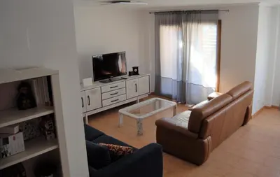 a living room with a couch and a tv at Chalet adosado en Costa Miño a un paso de la playa in Miño
