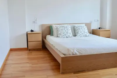 a bedroom with a bed and two night stands at Chalet adosado en Costa Miño a un paso de la playa in Miño