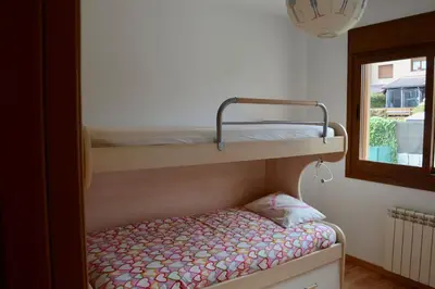 two bunk beds in a room with a window at Chalet adosado en Costa Miño a un paso de la playa in Miño