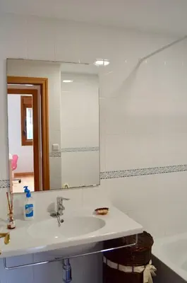 a white bathroom with a sink and a mirror at Chalet adosado en Costa Miño a un paso de la playa in Miño