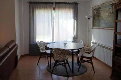 a table and chairs in a room with a window at Chalet adosado en Costa Miño a un paso de la playa in Miño