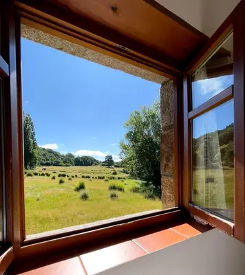 a window in a room with a view of a field at El Mirador de Sanabria in Galende