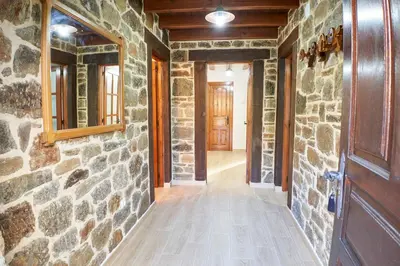 a hallway with a stone wall and a wooden door at El Mirador de Sanabria in Galende