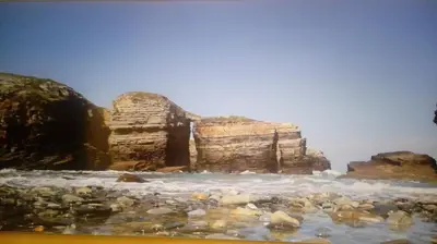 a group of rocks on a beach with the ocean at Foz vacaciones a orillas del mar in Foz