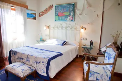 a bedroom with a bed and two chairs at Casa de Sixto in Paderne