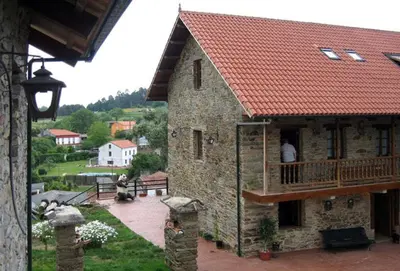 a building with a balcony and a person on a porch at Casa de Sixto in Paderne