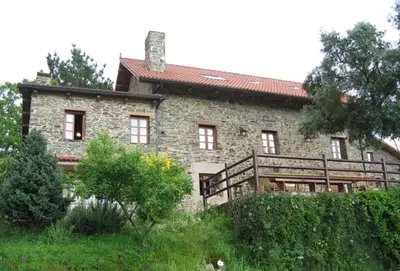 a large stone house with a red roof at Casa de Sixto in Paderne