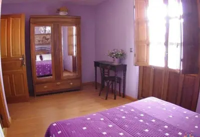 a bedroom with a bed and a table and a cabinet at Hotel Rural La Veleta in Murias de Rechivaldo