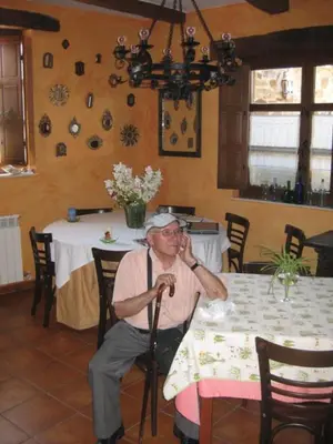 a man sitting at a table talking on a microphone at Hotel Rural La Veleta in Murias de Rechivaldo