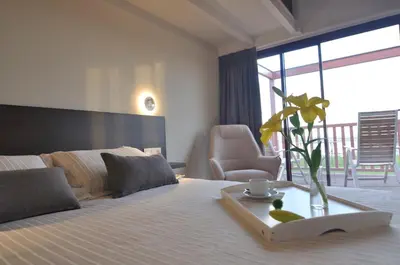 a hotel room with a bed with a vase on it at Cabanas Da Barcela in Barreiros