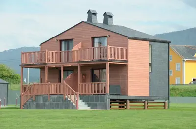 a large house with a deck on the side of it at Cabanas Da Barcela in Barreiros