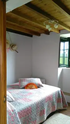 a bedroom with a bed and a wooden ceiling at A Minguxaina in Ribadeo
