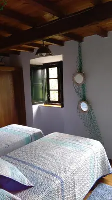 a bedroom with two beds and a window at A Minguxaina in Ribadeo