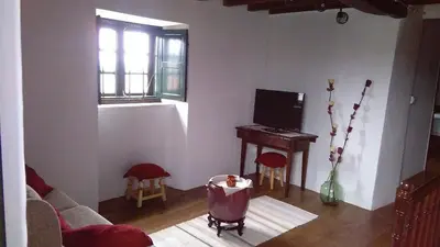 a living room with a couch and a piano at A Minguxaina in Ribadeo