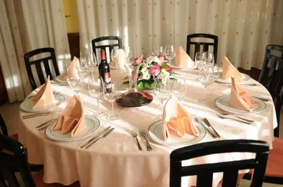 a table with a white table cloth with plates and napkins at Hotel Garcas in Lavacolla