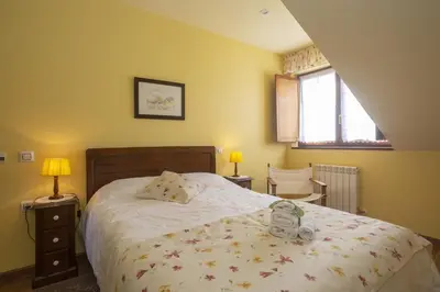 a bedroom with a bed with a teddy bear on it at Hotel Rural As Laguas in Tapia de Casariego