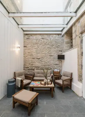 a patio with couches and tables and a brick wall at Albergue The Last Stamp in Santiago de Compostela