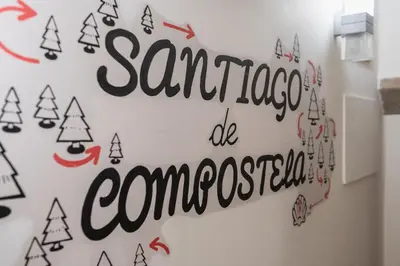 a white wall with a sign that reads santaaggia us commarcosity at Albergue The Last Stamp in Santiago de Compostela