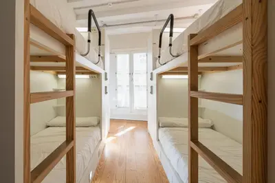 two bunk beds in a room with wood floors at Albergue The Last Stamp in Santiago de Compostela