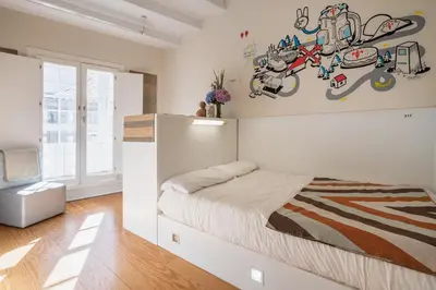 a bedroom with a large white bed with a wall at Albergue The Last Stamp in Santiago de Compostela