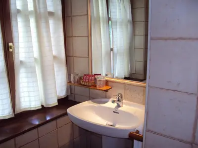 a bathroom with a sink and two windows at Hotel Rural Valle de Ancares in Pereda de Ancares