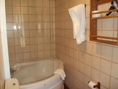 a white bathroom with a tub and a toilet at Hotel Rural Valle de Ancares in Pereda de Ancares