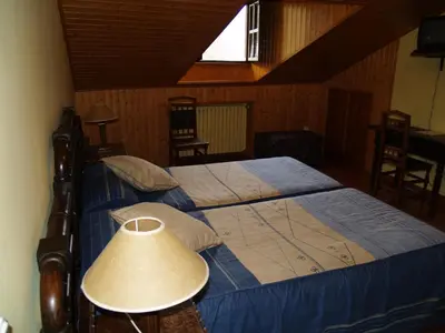 a bedroom with a large bed with a lamp on it at Hotel Rural Valle de Ancares in Pereda de Ancares