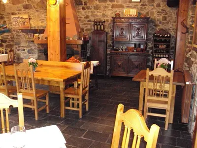 a dining room with a wooden table and chairs at Hotel Rural Valle de Ancares in Pereda de Ancares