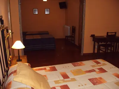 a bedroom with a bed and a table in a room at Hotel Rural Valle de Ancares in Pereda de Ancares