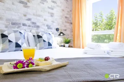 a bed with a tray of food and a glass of orange juice at CON PARKING, LocalizacIon Sensacional in Santiago de Compostela