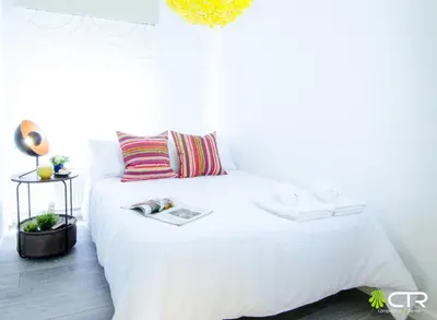 a bedroom with a white bed with a book on it at CON PARKING, LocalizacIon Sensacional in Santiago de Compostela
