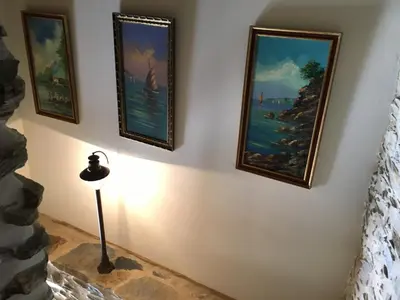 a group of paintings on a wall with a lamp at CASA RURAL BIERZO ENCANTADO in Valle de Finolledo