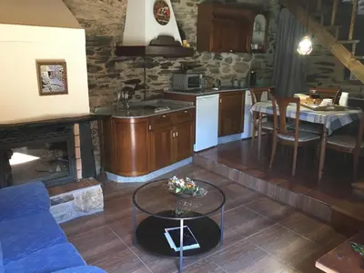 a kitchen and living room with a couch and a table at CASA RURAL BIERZO ENCANTADO in Valle de Finolledo