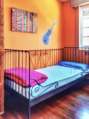 a bedroom with a bed with a guitar on the wall at Meiga Backpackers Hostel in Santiago de Compostela